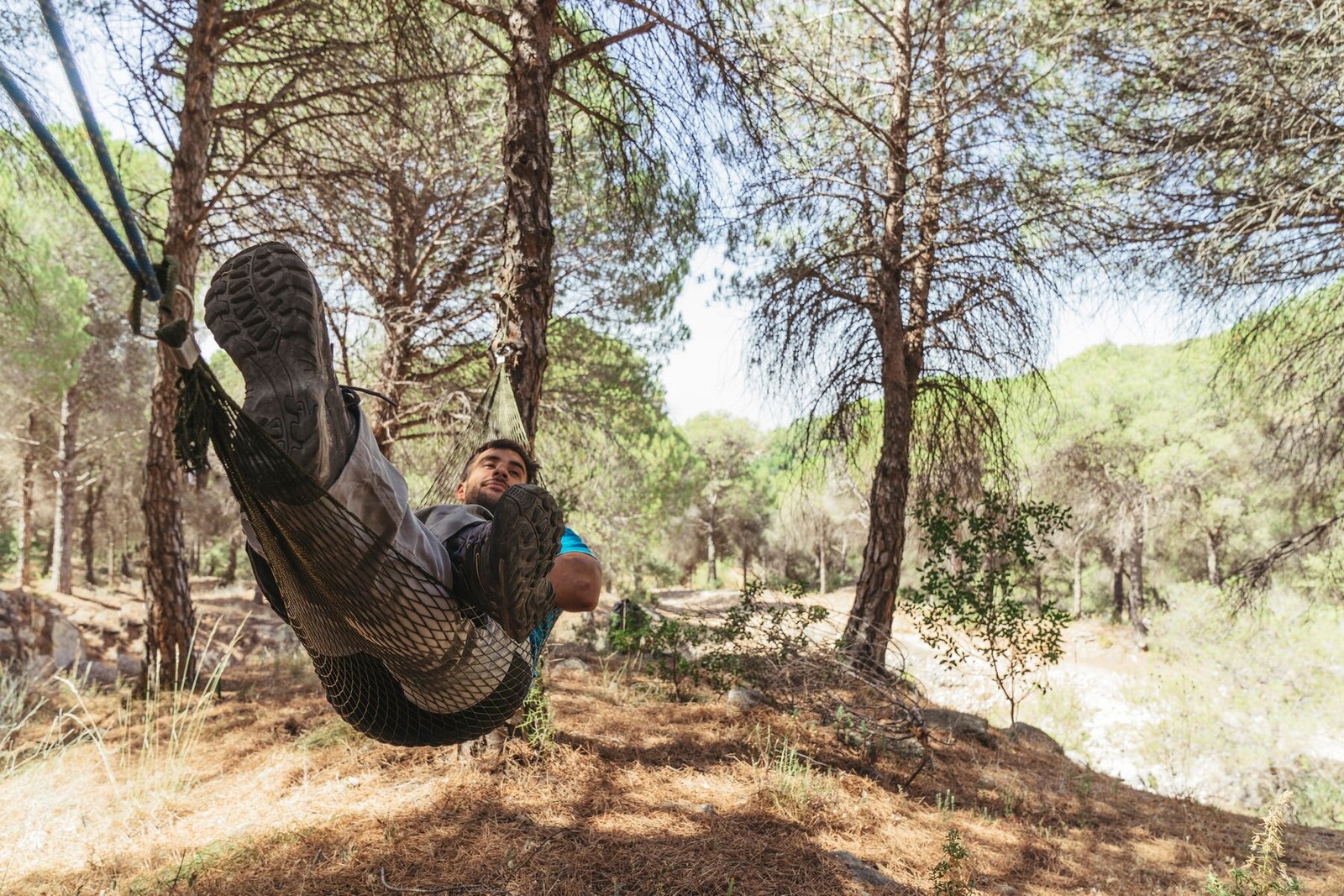 man-lying-hammock-forest_23-2147665080